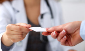 Doctor giving prescription to patient