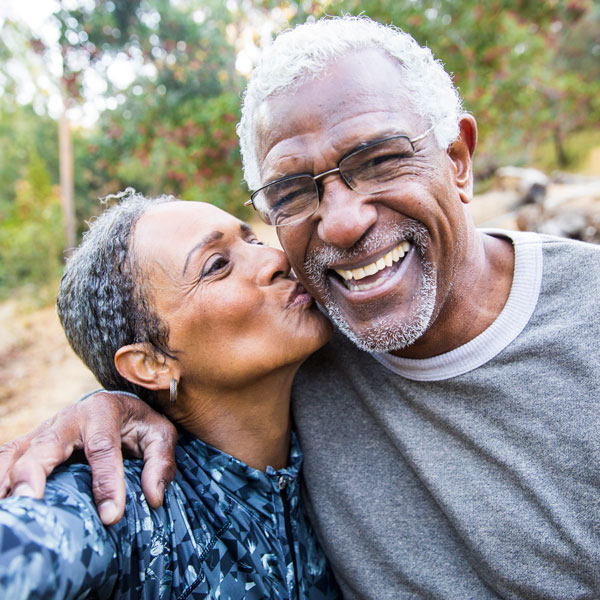 senior woman kissing man on cheek